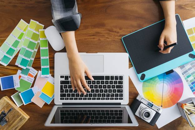 Young Graphic designer using graphics tablet to do his work at desk