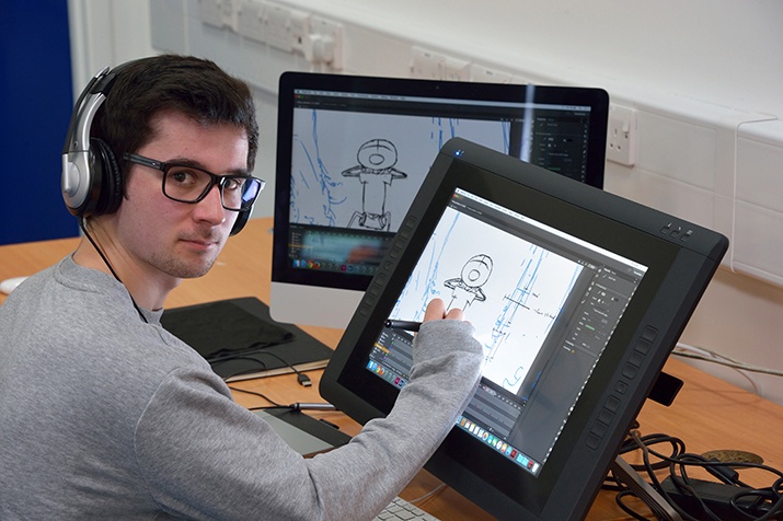 An animator working on Illustrater in his working area and tarring towards the camera.